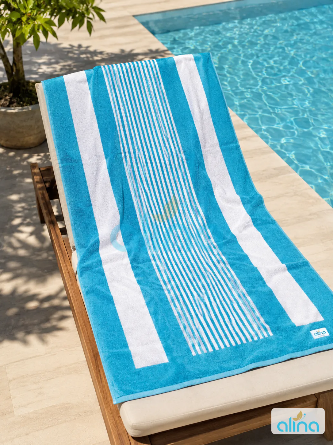 Blue and white striped hospitality pool towel on a resort lounger