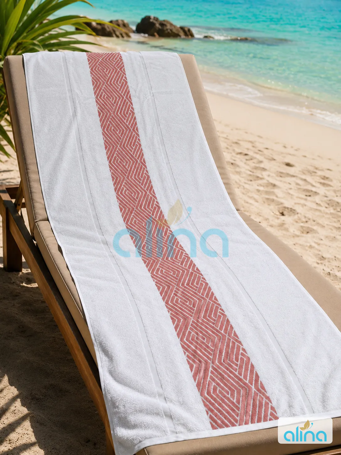 White and coral geometric hospitality towel on a beach lounger