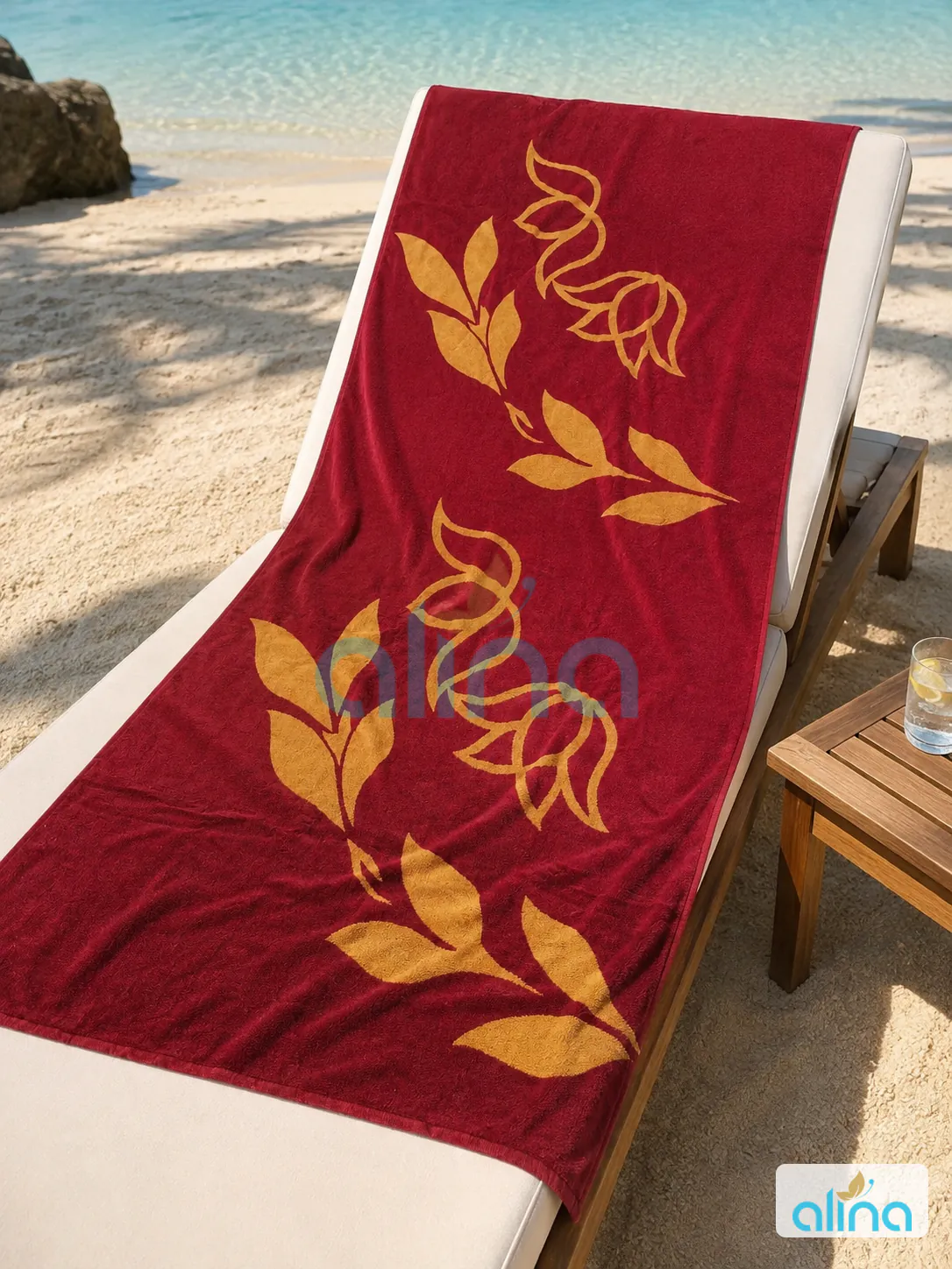 Red and gold floral hospitality towel on a beach lounger